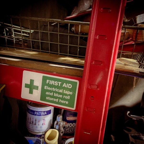 Funny "safety" sticker - FIRST AID: Electrical tape and blue roll stored here